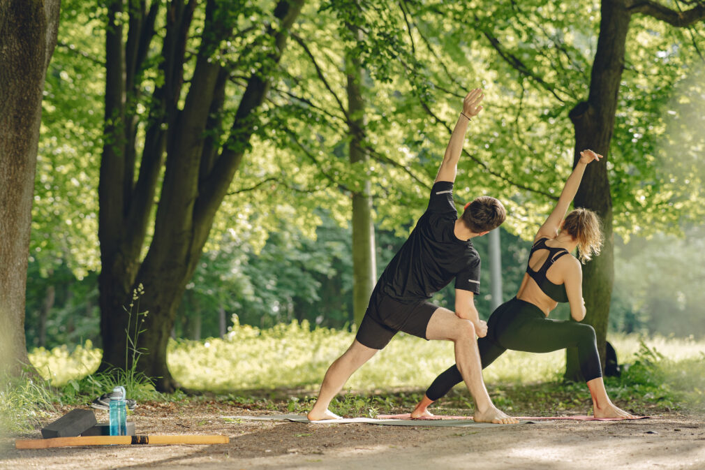 Man and woman doing yoga exercises in the park