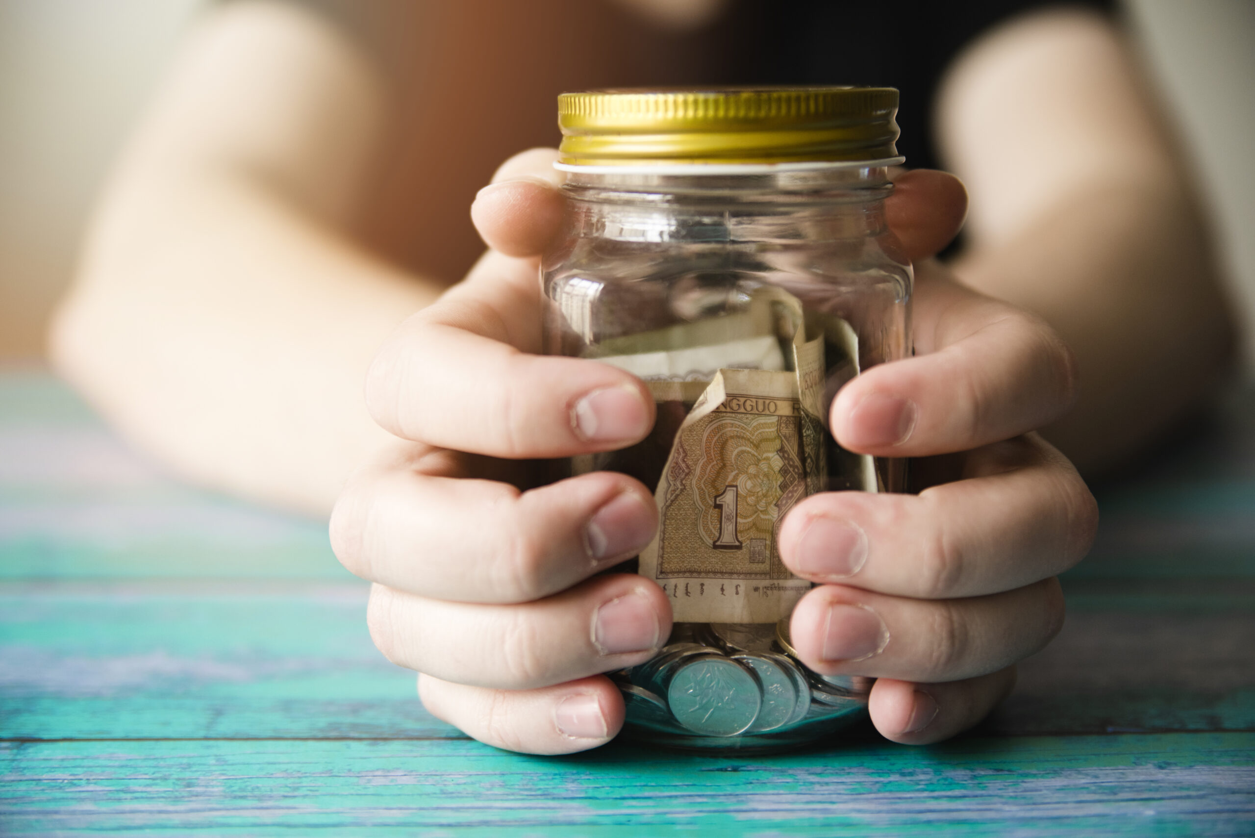 hands-holding-savings-jar